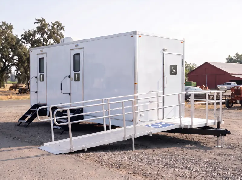 ADA restroom trailer with a wheelchair ramp and handrails