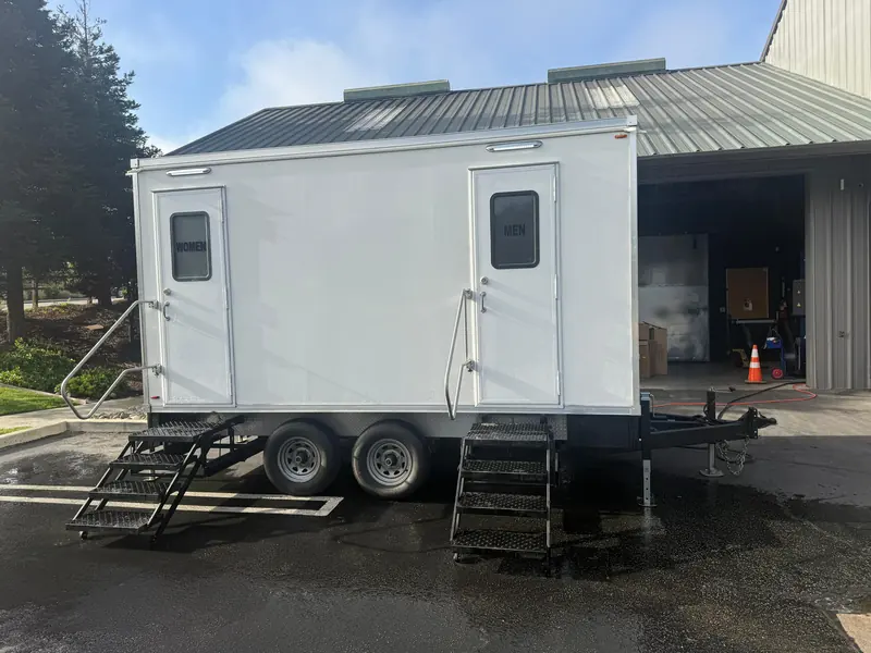 Restroom trailer parked on a gravel jobsite lot