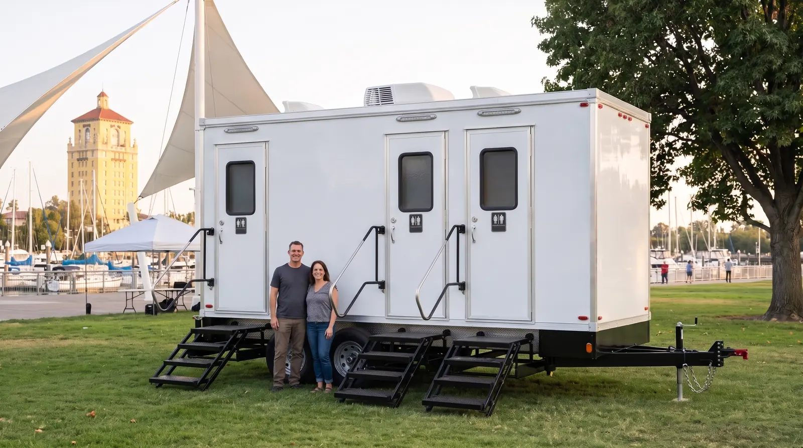 Families at a Weber Point festival in downtown Stockton beside a white restroom trailer